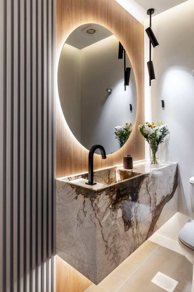 Design minimalista: apê em Jurerê Internacional une funcionalidade e elegância. Projeto de Jeane Silva. Na foto, lavabo com espelho redondo.