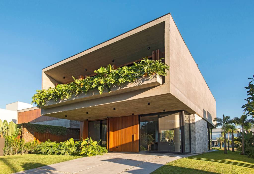 Casa de praia de 406 m² combina brutalismo, arte e sustentabilidade. Projeto de Mayresse Arquitetura. Na foto, fachada de casa com dois volumes.