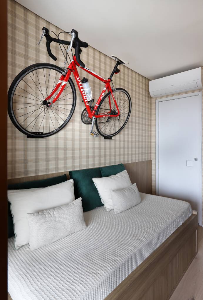 TV que sai do teto? Apê recebe inúmeras soluções inteligentes que valorizam a metragem. Projeto de Dudi Duarte e marcenaria de SCA Jardim Europa. Na foto, espaço de home office e quarto de hóspede com bicicleta como decoração.