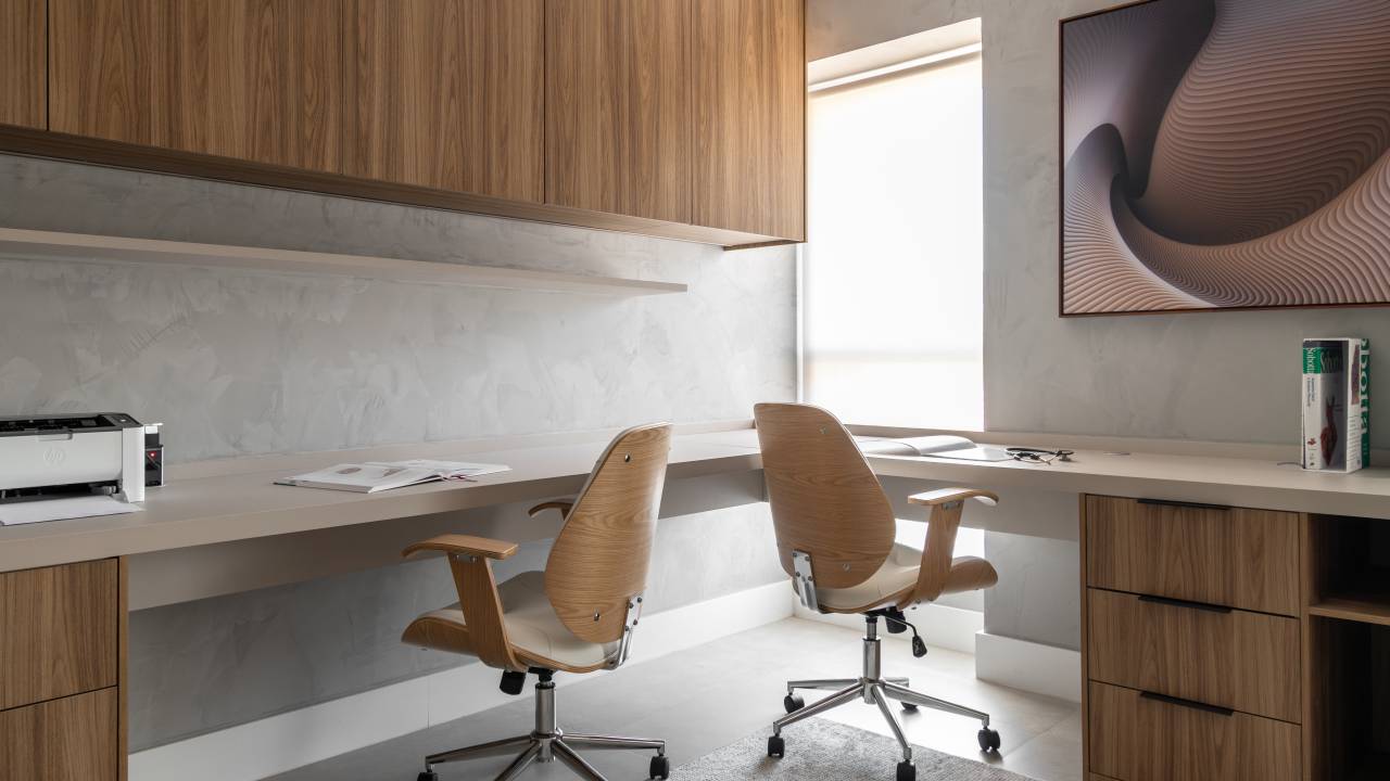 Cama embutida na parede faz sala de estar ser quarto neste apê de 89 m². Projeto de DGL Arquitetura. Na foto, home office minimalista.