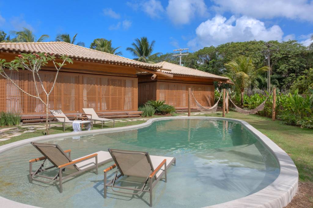Casa de praia térrea é dividida em 5 módulos e tem decoração rústica. Projeto de DB Arquitetos.