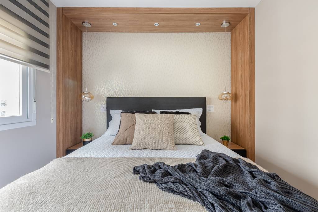 Sala de apartamento tem painéis de laca e pórtico de granito Preto São Gabriel. Projeto de RMV Interiores.