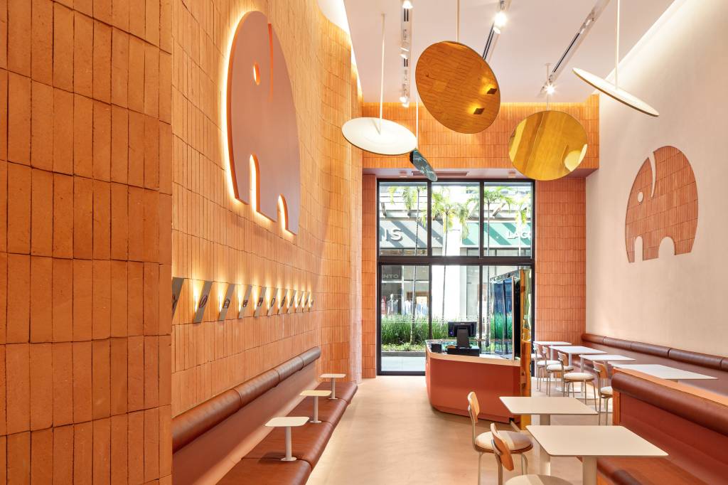 Tons terrosos e toques de dourado aquecem os interiores do We Coffee