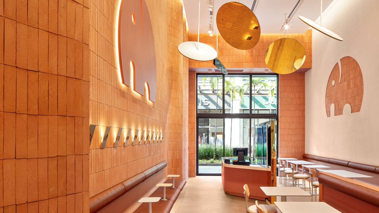 Tons terrosos e toques de dourado aquecem os interiores do We Coffee. Projeto de Pitá Arquitetura.