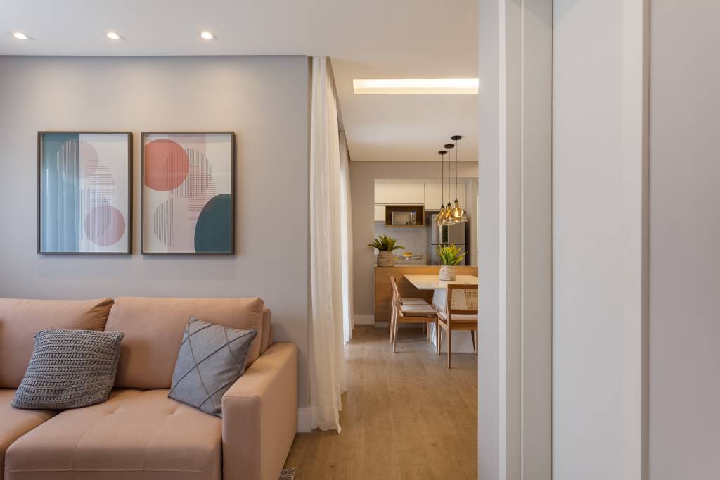 Varanda de apartamento tem serralheria preta com nichos e rede amarela. Projeto de RMV Interiores.