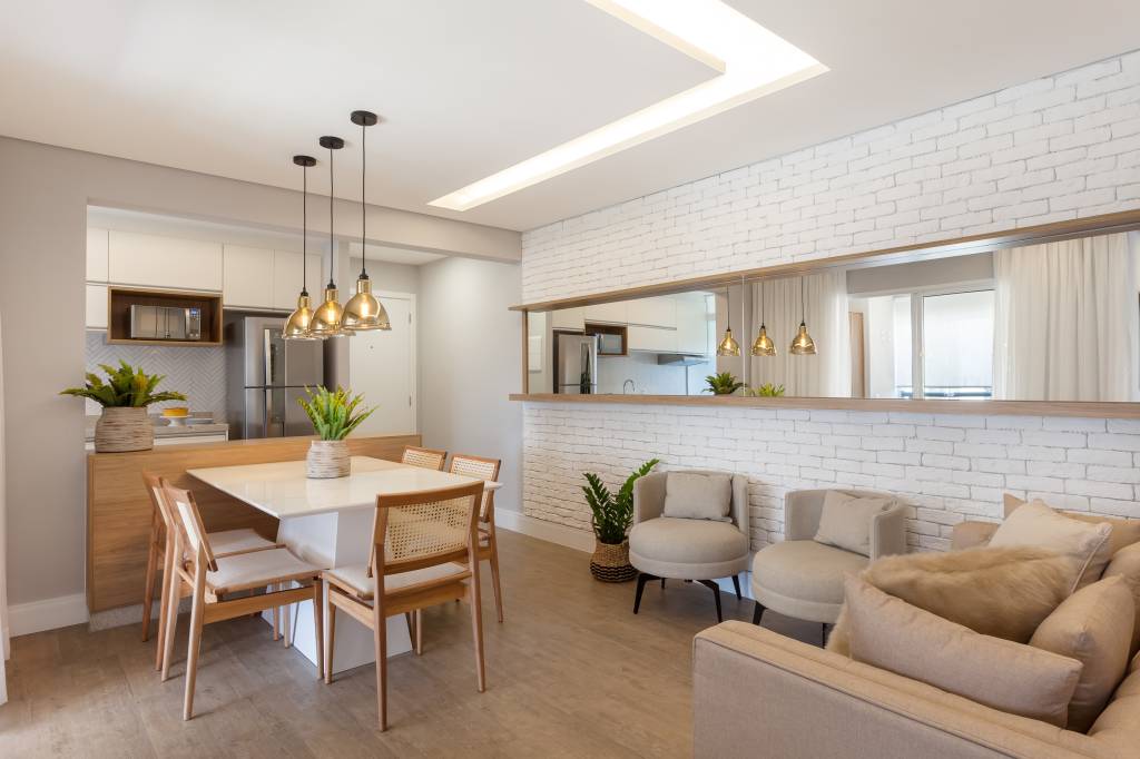 Varanda de apartamento tem serralheria preta com nichos e rede amarela. Projeto de RMV Interiores.