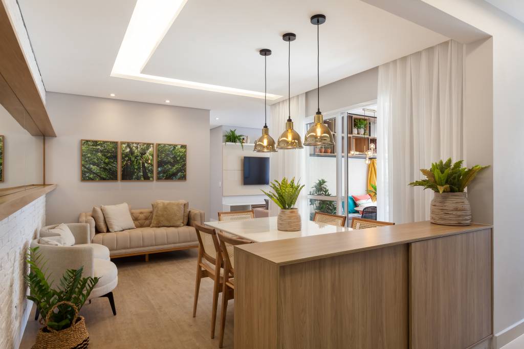 Varanda de apartamento tem serralheria preta com nichos e rede amarela. Projeto de RMV Interiores.