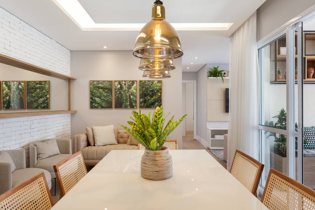 Varanda de apartamento tem serralheria preta com nichos e rede amarela. Projeto de RMV Interiores.