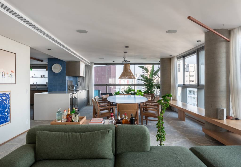 Apê de 333m² tem piso em pedra natural. Projeto de Labra Arquiteto. Na foto, sala de jantar, estar e cozinha integradas.
