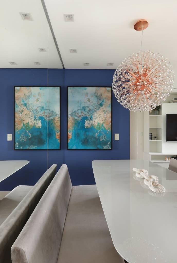 Armários em laca azul se destacam na cozinha deste apartamento. Projeto de RMV Interiores. Na foto, sala de jantar com parede azul.