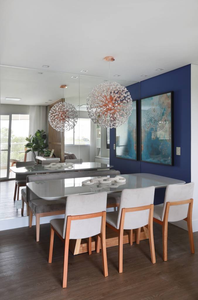Armários em laca azul se destacam na cozinha deste apartamento. Projeto de RMV Interiores. Na foto, sala de jantar com luminária pendente.