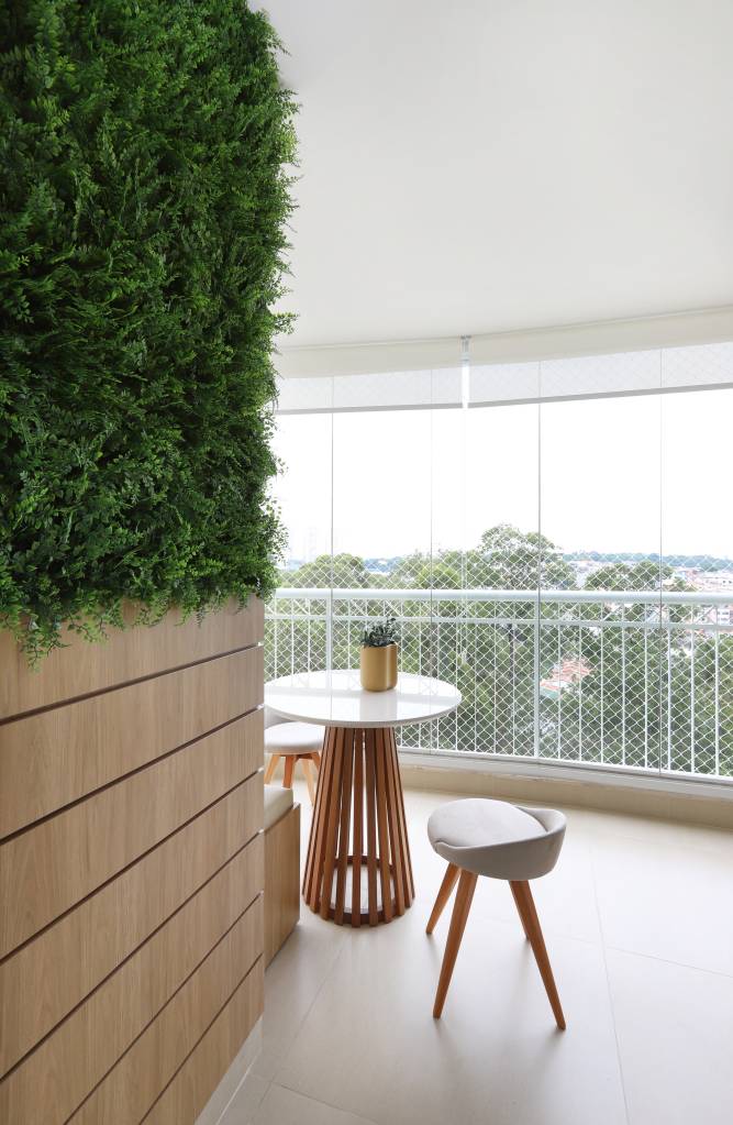 Armários em laca azul se destacam na cozinha deste apartamento. Projeto de RMV Interiores. Na foto, varanda com jardim vertical.