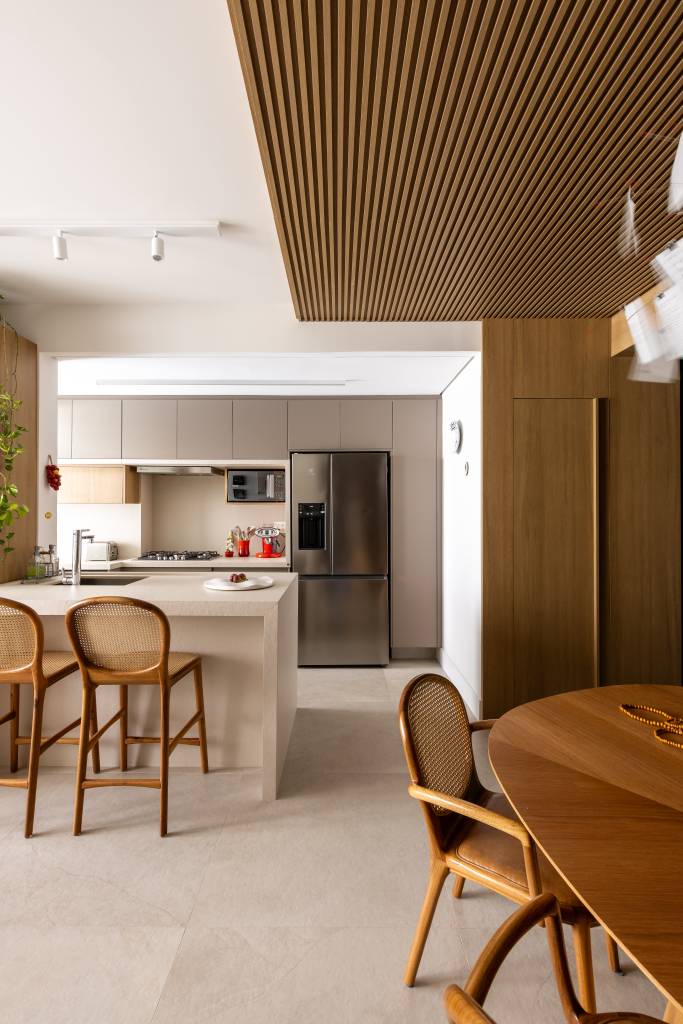 Arquiteta projeta o próprio apartamento e aposta em diferentes revestimentos. Projeto de Elisa Maretti. Na foto, balcão com banquetas na cozinha.