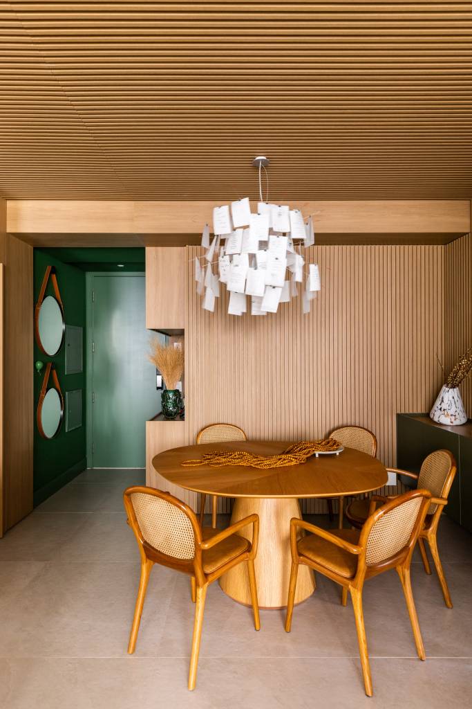 Arquiteta projeta o próprio apartamento e aposta em diferentes revestimentos. Projeto de Elisa Maretti. Na foto, luminária pendente na sala de jantar.