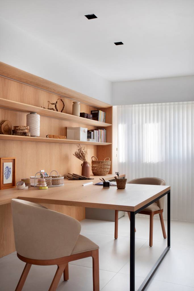 “Caixa” de madeira mimetizada esconde a porta de entrada deste apartamento e dá acesso à cozinha e ao lavabo. Projeto de Natalia Lemos Arquitetura.