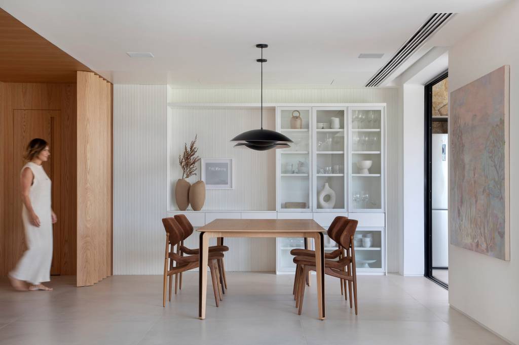 “Caixa” de madeira mimetizada esconde a porta de entrada deste apartamento e dá acesso à cozinha e ao lavabo. Projeto de Natalia Lemos Arquitetura.