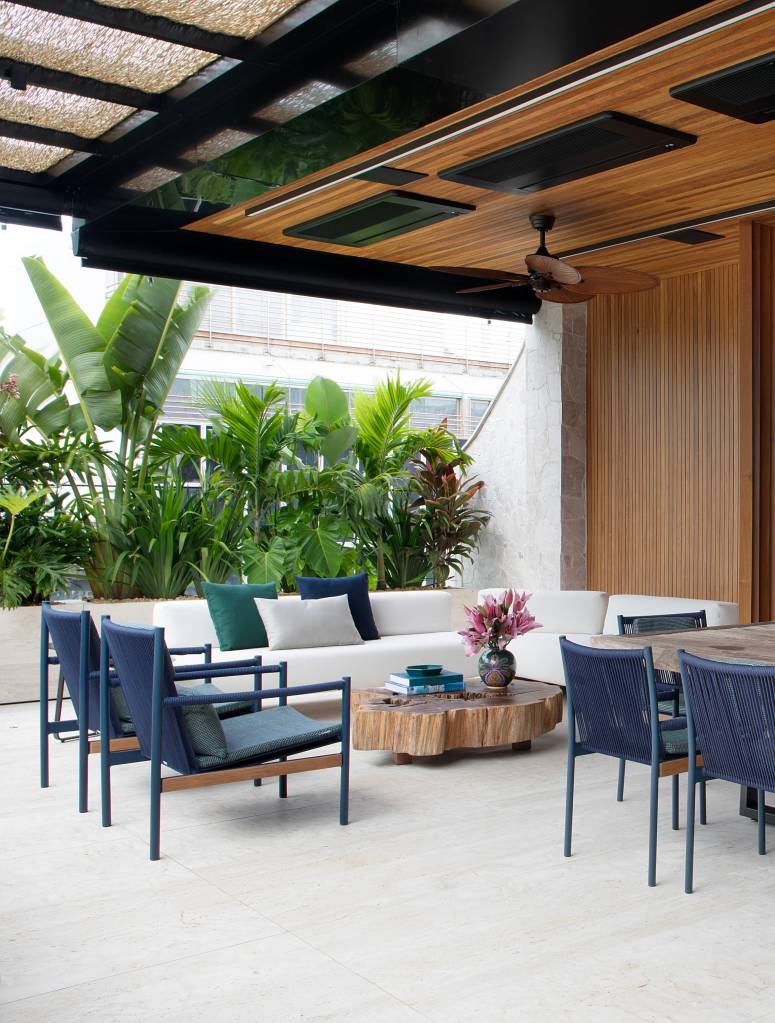 Jardineiras em mármore com plantas altas garantem privacidade neste apê. Projeto de Bianca da Hora. Na foto, terraço com plantas altas.