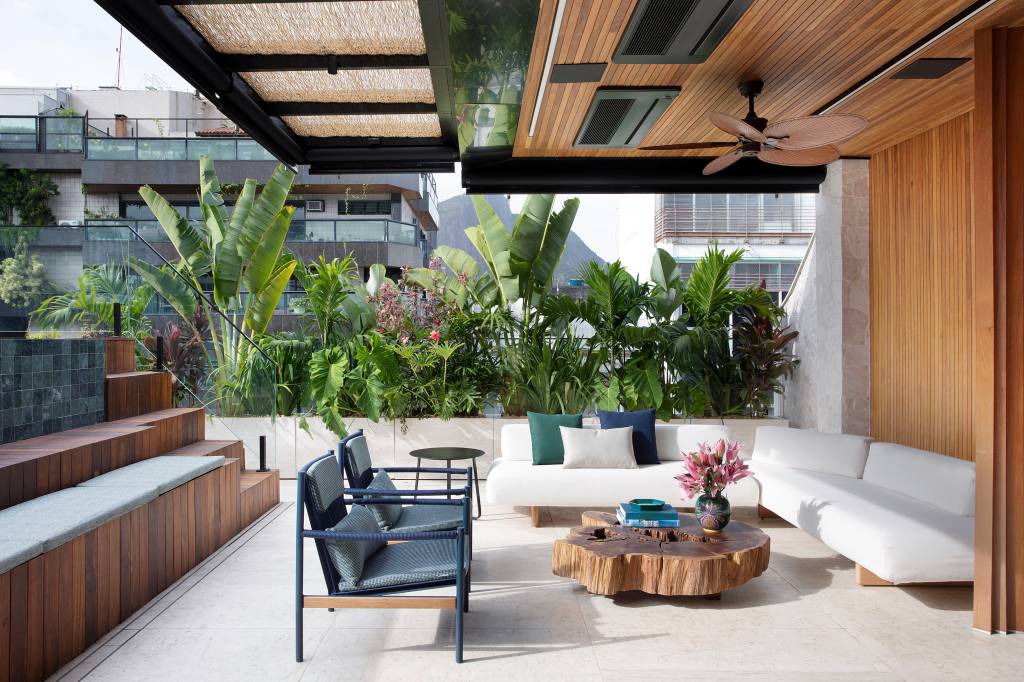 Jardineiras em mármore com plantas altas garantem privacidade neste apê. Projeto de Bianca da Hora. Na foto, terraço com espaço de convivência.