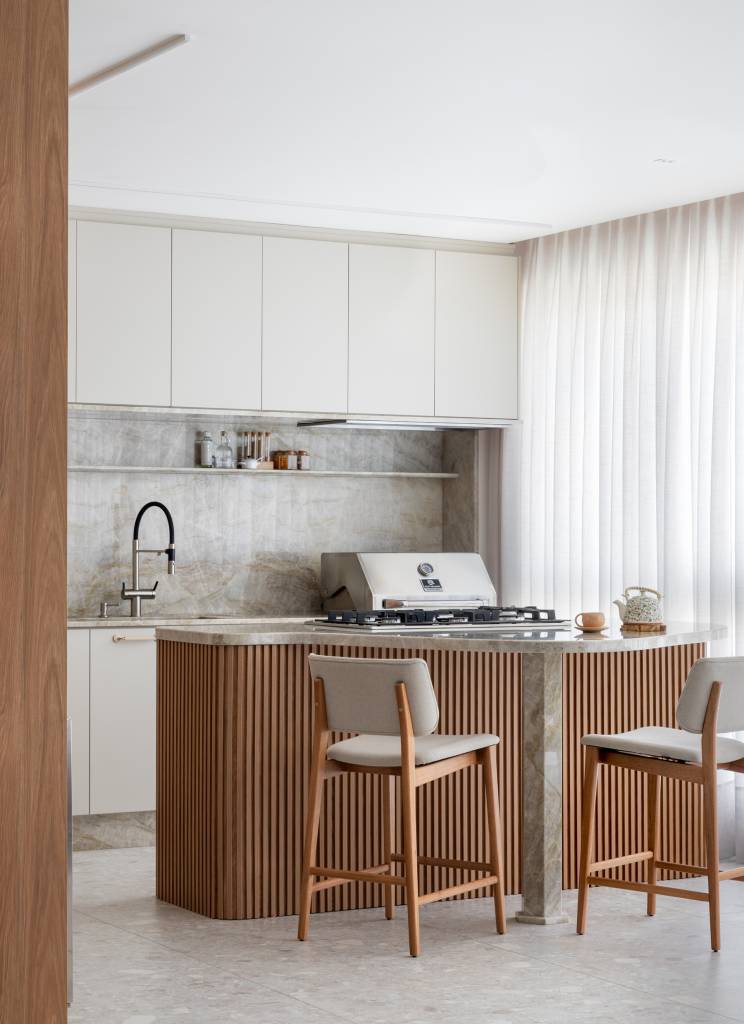 Lareira em mármore verde se destaca em apartamento de 170 m². Projeto de Natan Hostins Design. Na foto, cozinha com ilha central.