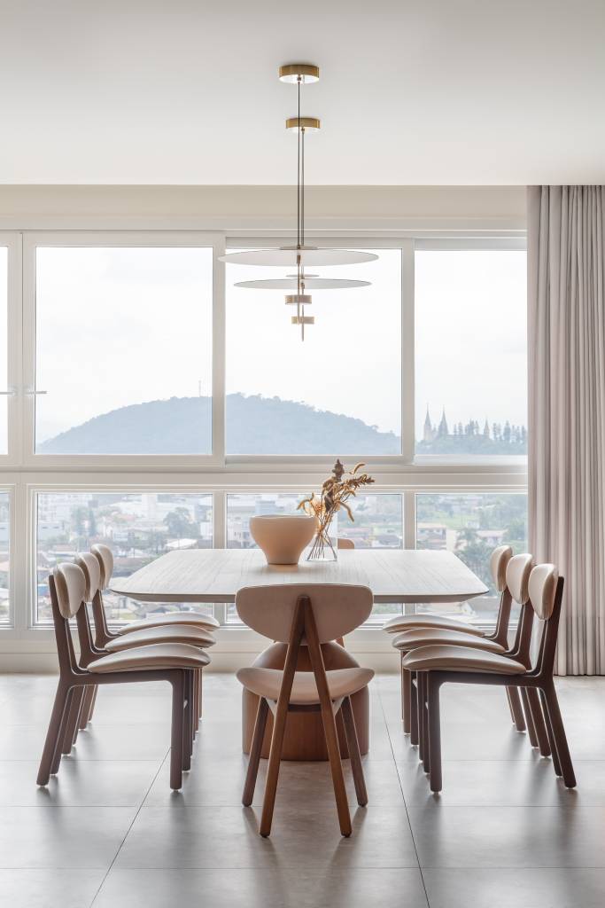 Lareira em mármore verde se destaca em apartamento de 170 m². Projeto de Natan Hostins Design. Na foto, sala de jantar com vista para a cidade.