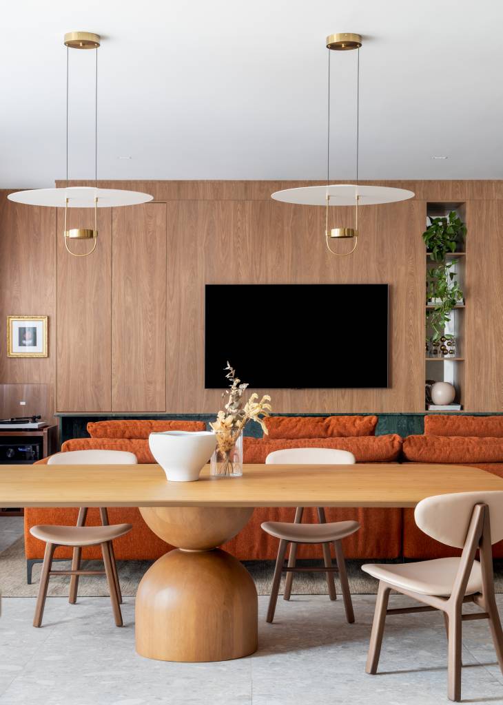 Lareira em mármore verde se destaca em apartamento de 170 m². Projeto de Natan Hostins Design. Na foto, sala de estar integrada com sala de jantar.
