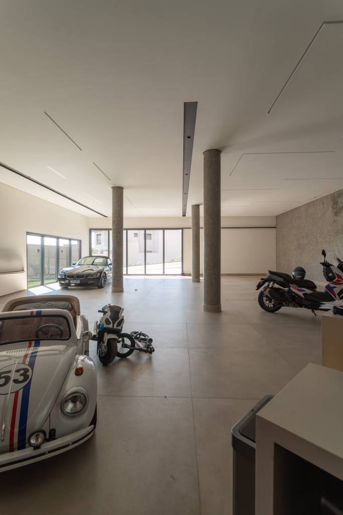 Residência de 714m² une arquitetura e paisagem em perfeita harmonia. Projeto de Casalli Arquitetura. Na foto, garagem extensa e minimalista.