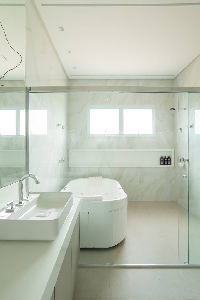 Residência de 714m² une arquitetura e paisagem em perfeita harmonia. Projeto de Casalli Arquitetura. Na foto, banheiro com banheira dentro do box.