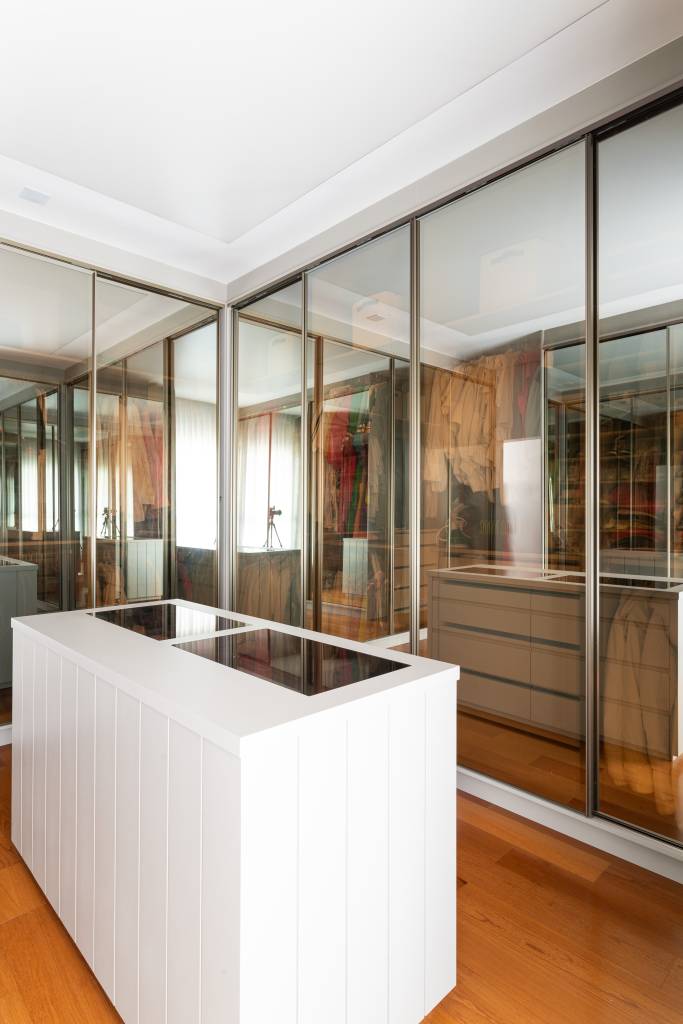 Residência de 714m² une arquitetura e paisagem em perfeita harmonia. Projeto de Casalli Arquitetura. Na foto, closet com portas espelhadas.