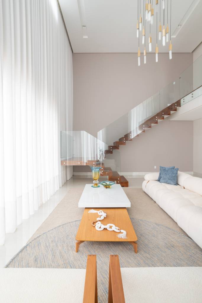 Residência de 714m² une arquitetura e paisagem em perfeita harmonia. Projeto de Casalli Arquitetura. Na foto, escada com guarda-corpo de vidro.