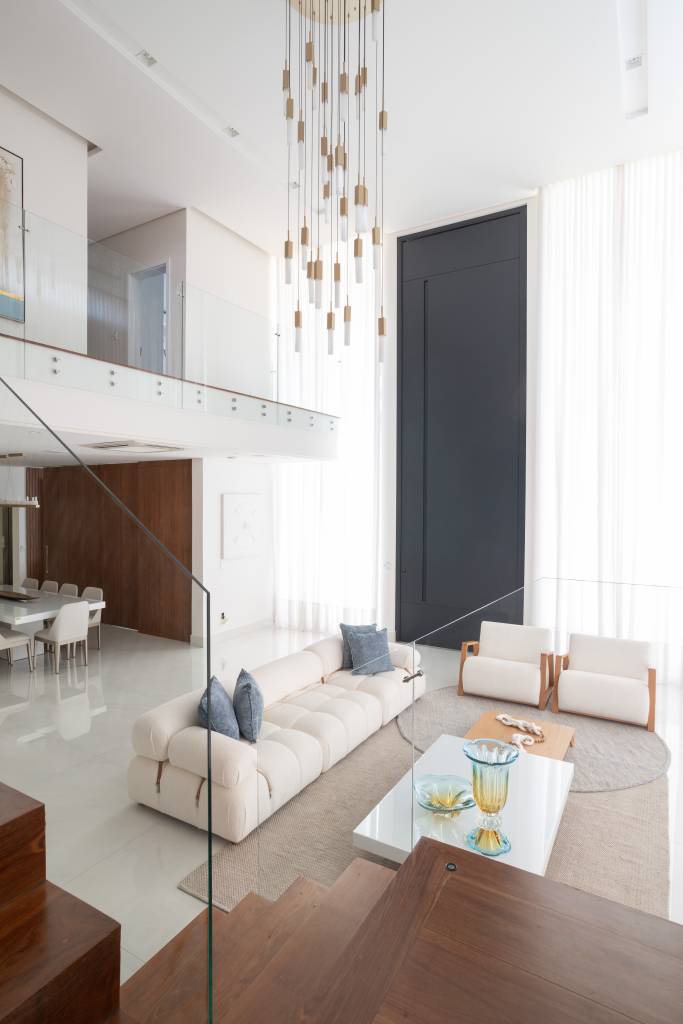 Residência de 714m² une arquitetura e paisagem em perfeita harmonia. Projeto de Casalli Arquitetura. Na foto, sala com sofás e poltronas neutras.