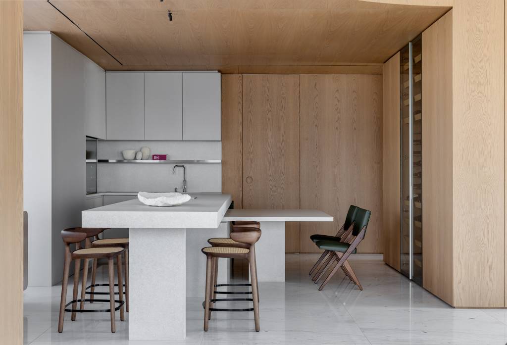 Sistema de caixas embutidas em painel de madeira é destaque neste apê. Projeto de Rauen Garbers Arquitetura.