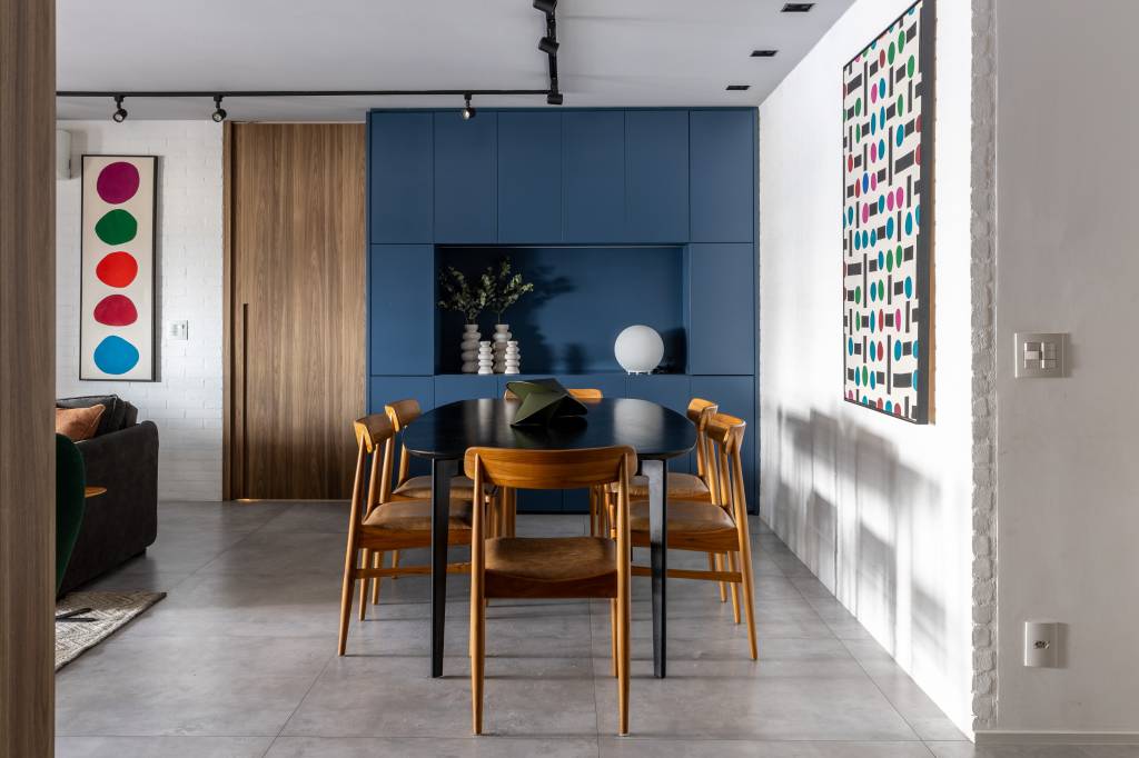 Apartamento descolado tem jardim vertical exuberante com samambaias e cozinha azul. Projeto de Flávia Campos.