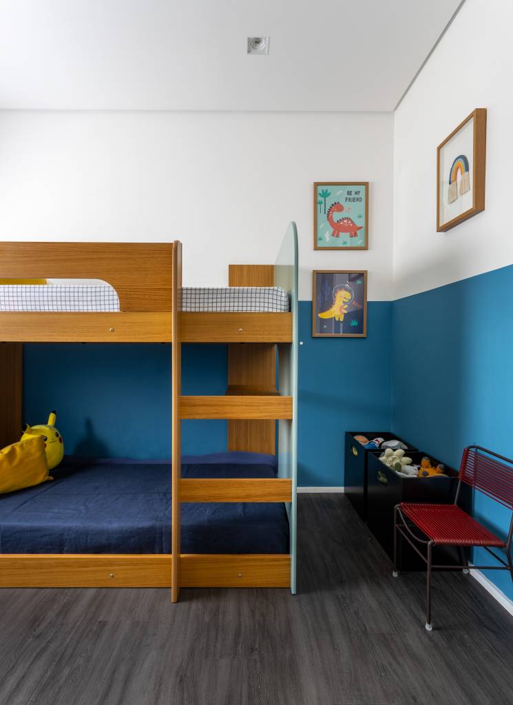 Apartamento descolado tem jardim vertical exuberante com samambaias e cozinha azul. Projeto de Flávia Campos.