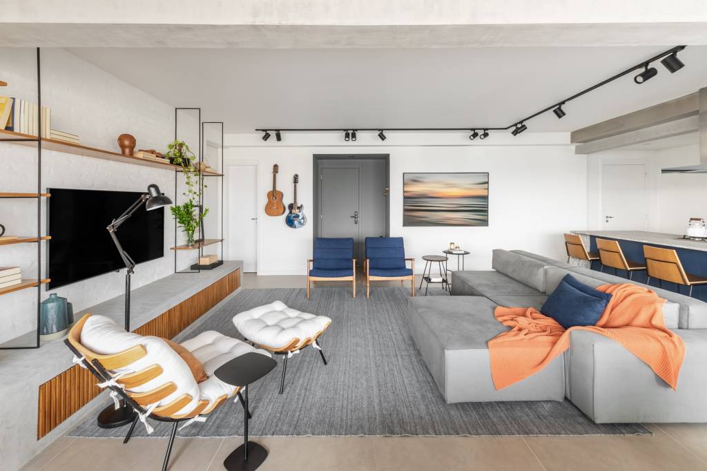 Apartamento integrado tem banco de concreto com futon na varanda. Projeto de Conectarq.