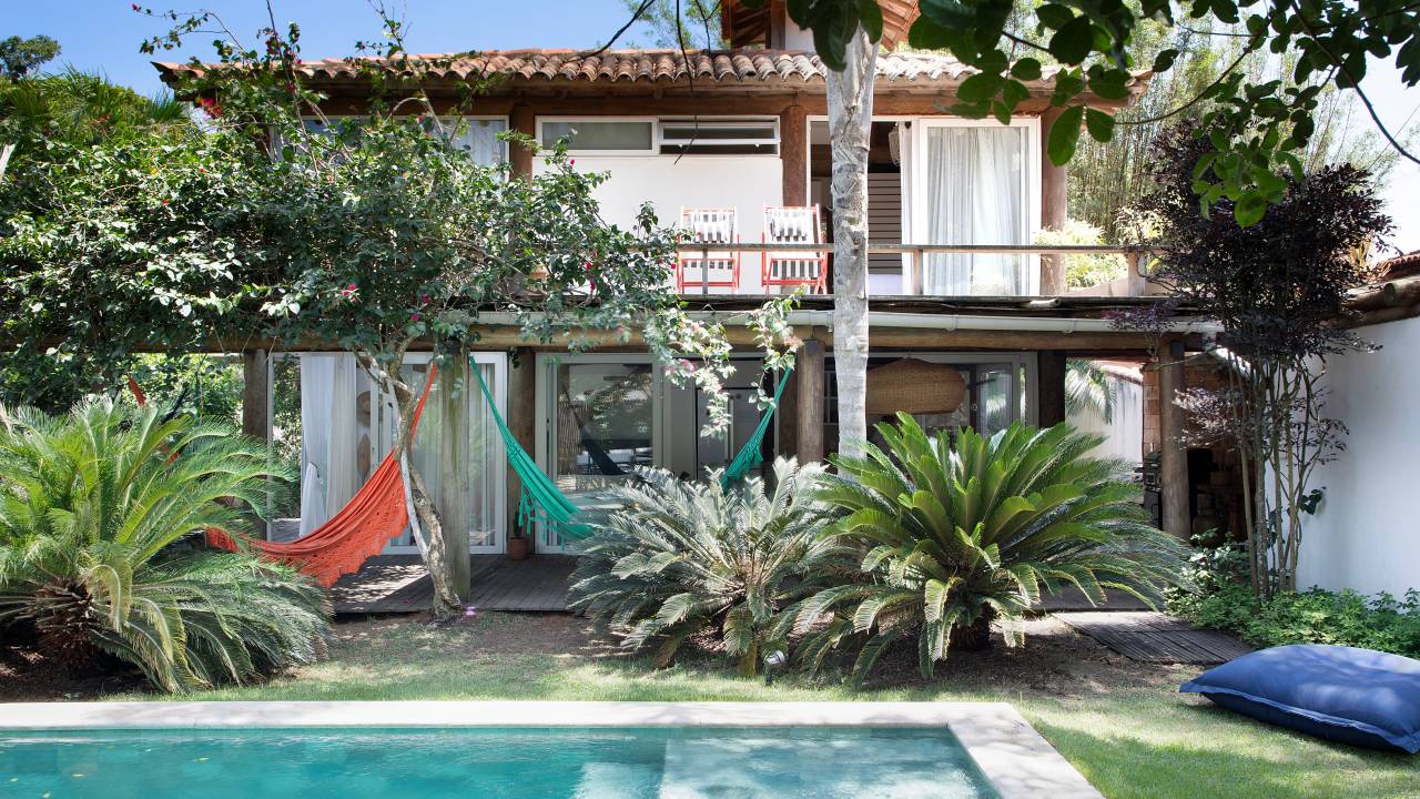 Casas de praia em Búzios com materiais ecológicos são interligadas por pergolado. Projeto de Mônica Gervásio.