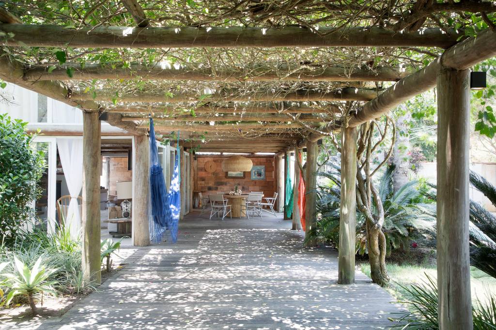 Casas de praia em Búzios com materiais ecológicos são interligadas por pergolado. Projeto de Mônica Gervásio.