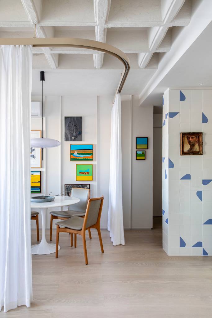 Cortina funciona como divisória em apartamento de 85 m² que tem home office com vista. Projeto de Pipa Arquitetura.