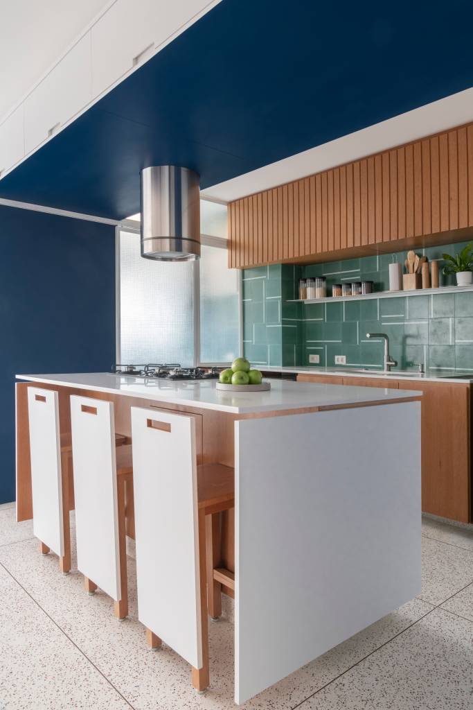 Cristaleira e pórtico são envolvidos por azul neste apartamento de 93 m². Projeto de COTA 760 Arquitetura.
