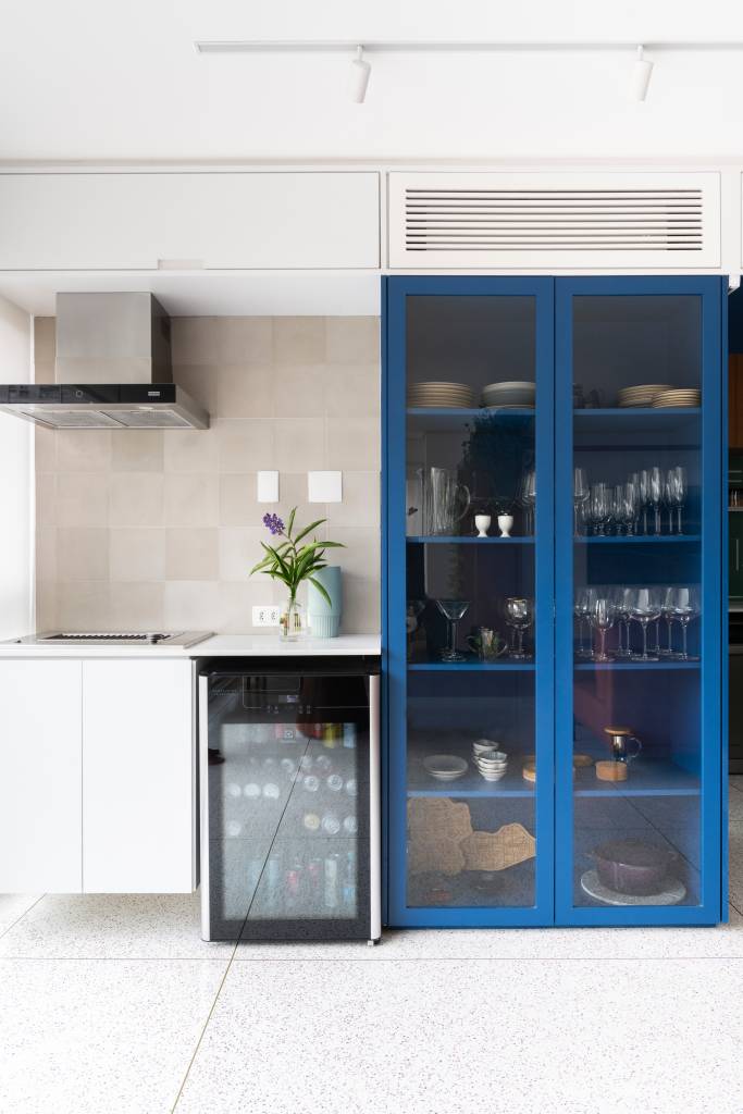 Cristaleira e pórtico são envolvidos por azul neste apartamento de 93 m². Projeto de COTA 760 Arquitetura.