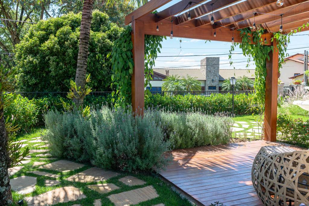 Jardim tem lindo caminho de pedras emoldurado por lavandas e gerânios. Projeto de paisagismo de Renata Guastelli.