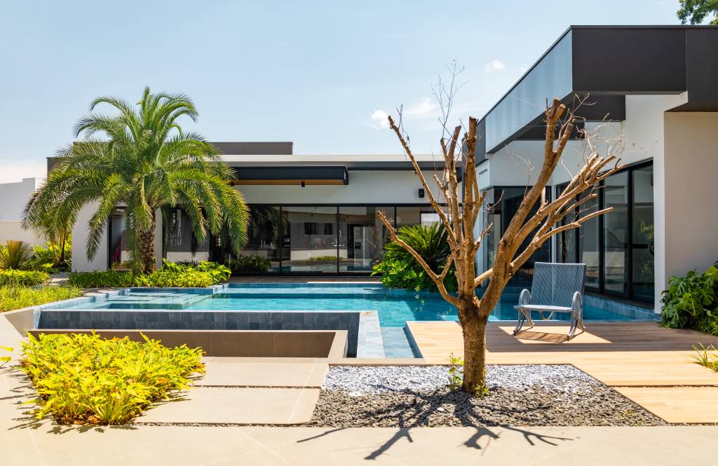 Lazer em foco: casa de condomínio tem piscina, lago e linda casa na árvore. Projeto de Natalia Sundfeld.