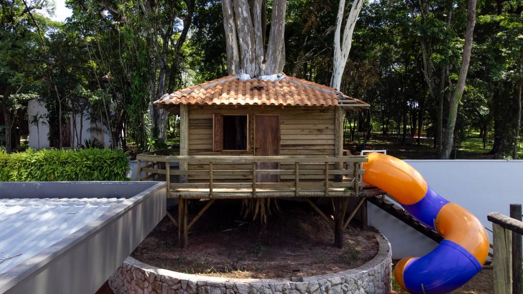 Lazer em foco: casa de condomínio tem piscina, lago e linda casa na árvore. Projeto de Natalia Sundfeld.