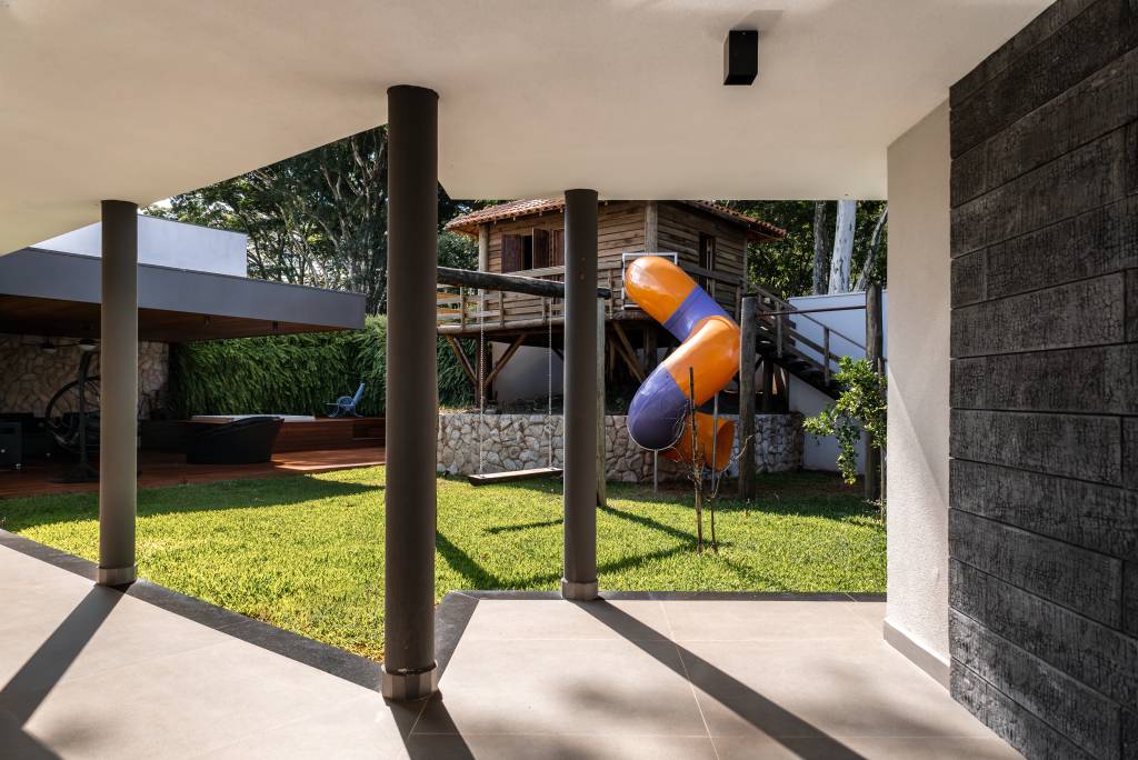Lazer em foco: casa de condomínio tem piscina, lago e linda casa na árvore. Projeto de Natalia Sundfeld.