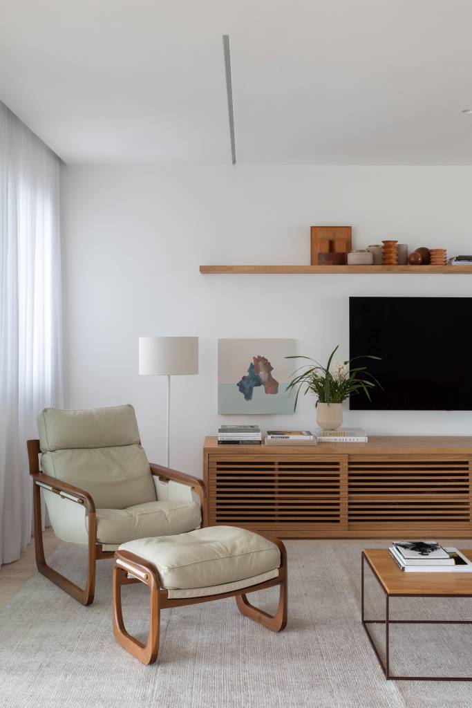 Neste apartamento, móvel multiuso em living abriga louceiro, adega e bar. Projeto de escritório LessaZanetta.