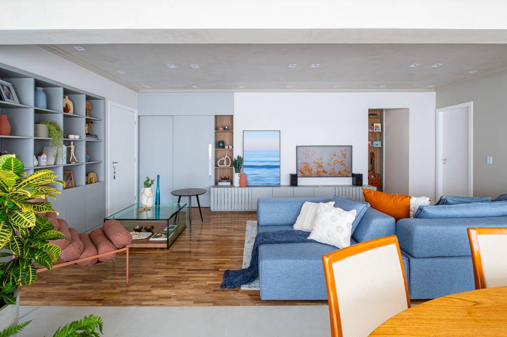 Neste apê, sofá com encosto removível pode se voltar para sala de estar ou área gourmet. Projeto de Go Up Arquitetura.