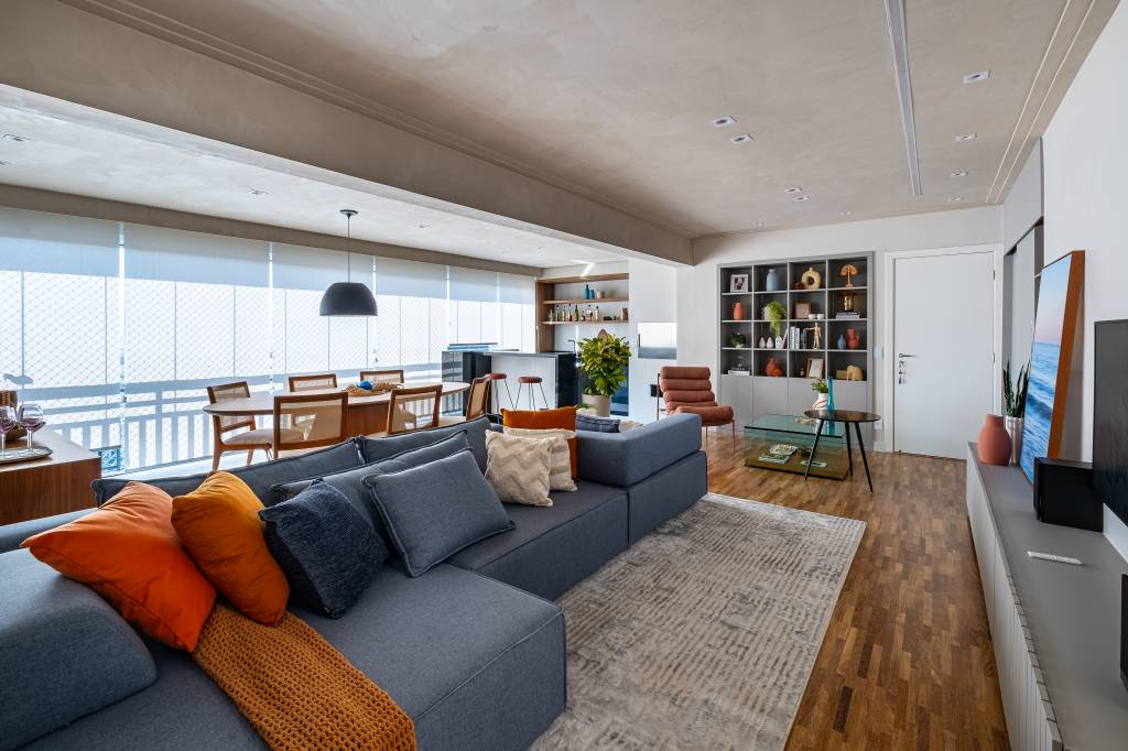 Neste apê, sofá com encosto removível pode se voltar para sala de estar ou área gourmet. Projeto de Go Up Arquitetura.