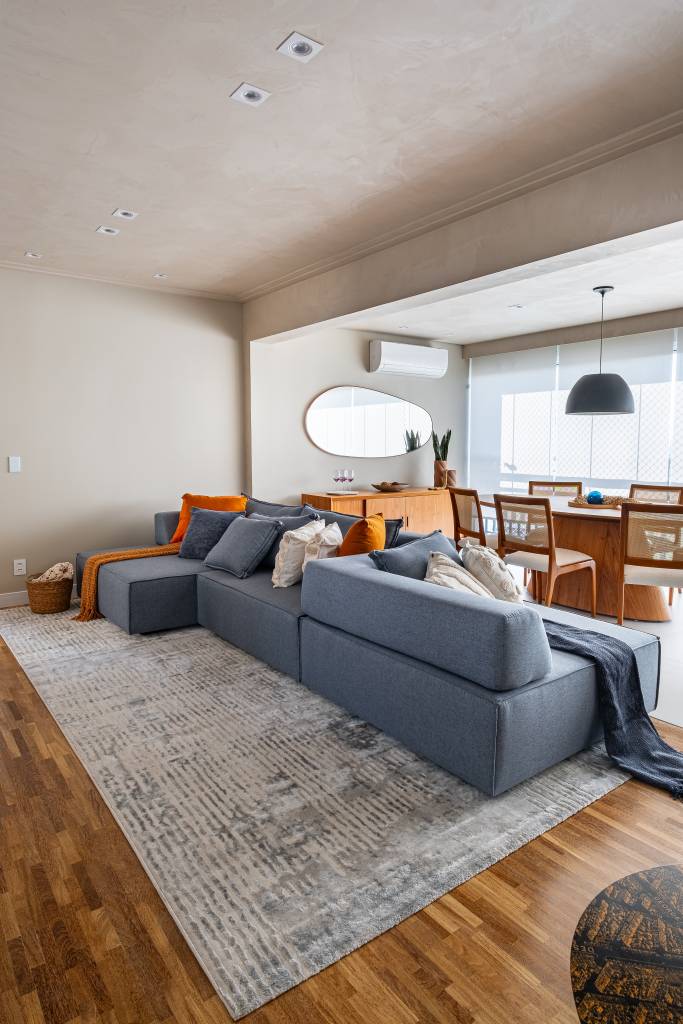 Neste apê, sofá com encosto removível pode se voltar para sala de estar ou área gourmet. Projeto de Go Up Arquitetura.
