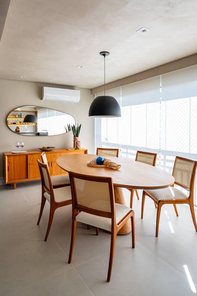 Neste apê, sofá com encosto removível pode se voltar para sala de estar ou área gourmet. Projeto de Go Up Arquitetura.