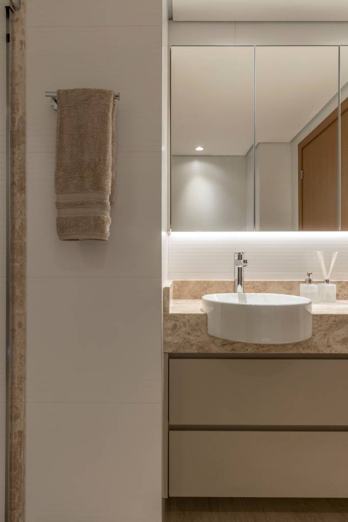 Painel de muxarabi esconde portas da cozinha e lavabo neste apartamento. Projeto de Hersen Mendes Arquitetura.