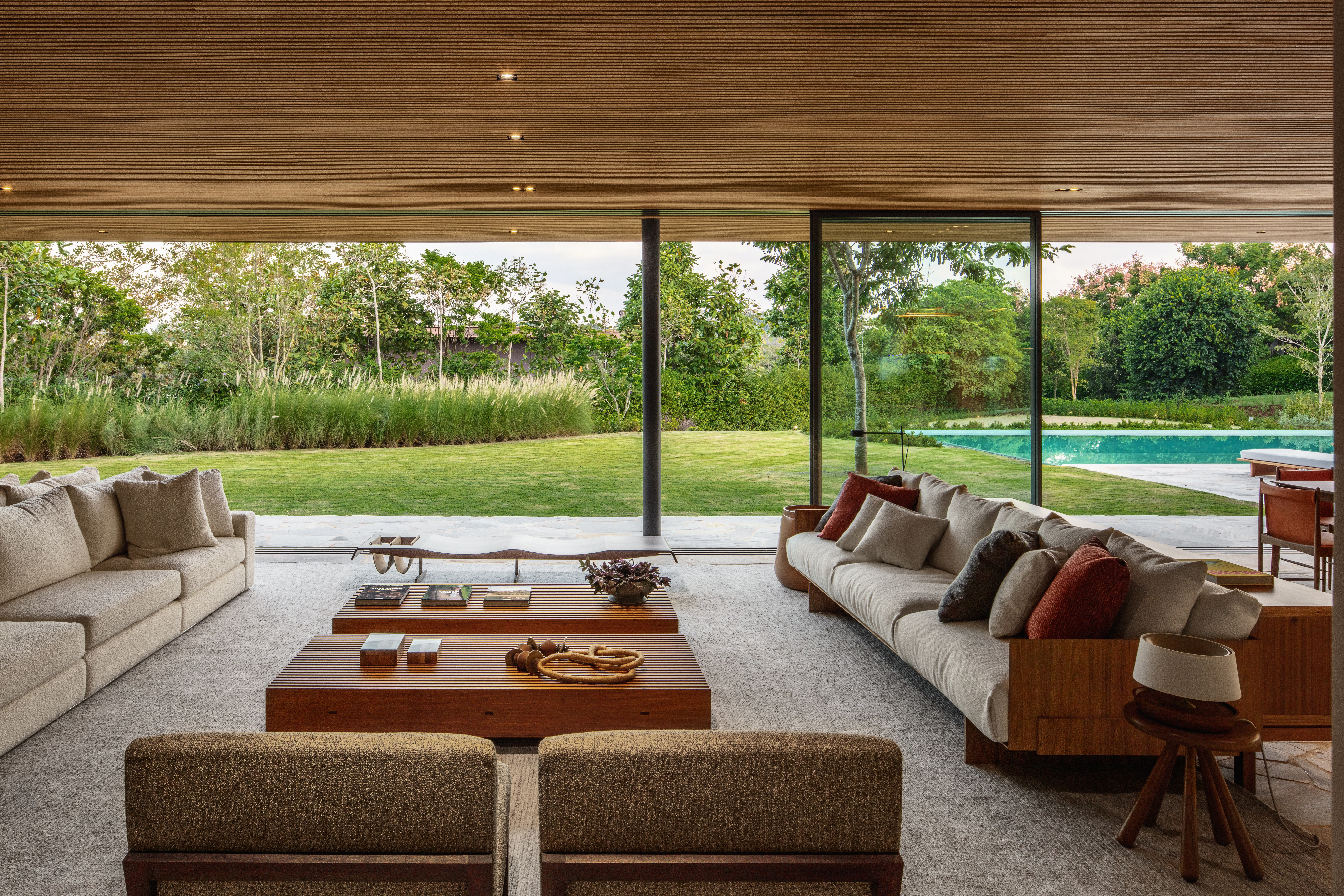 Casa sustentável no meio do mato usou brises para garantir privacidade. Projeto de Matheus Farah e Manoel Maia Arquitetura. Na foto, sala de estar com duas mesas de centro.